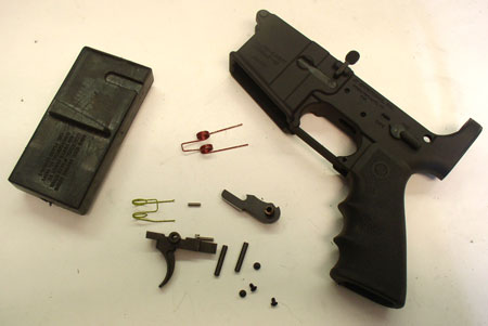 The contents of the package splayed about next to the mag well vise block and fire control-less receiver.