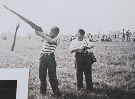 The author, circa 1955, trying to hold up his late father's M-1 while his younger brother Rick fiddles with his Kodak Brownie. In the background is part of Camp Perry's huge firing line.