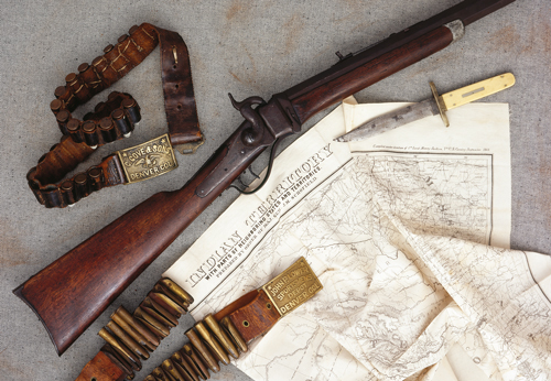 Converted by a gunsmith in Montana Territory c. 1870s. Standard Sharps Civil War cavalry issue carbine altered to a classic style “Buffalo Rifle” by A. B. Charpie of Helena, Montana Territory, whose name and markings appear on the heavyweight 24-inch octagon barrel; caliber 50 centerfire; overall weight 11-1/2 lbs. Illustrated here with a Sheffield, England-made Bowie knife of the same era made for and bearing the markings of the well-known Denver, Colorado gunsmith and arms merchant John P. Lower & Son; also leather cartridge belts bearing brass buckles sold by Lower and the equally noted Denver gunsmiths and arms dealers Carlos Gove & Sons. (As illustrated in The Peacemakers; Arms and Adventure in the American West, with author’s permission)