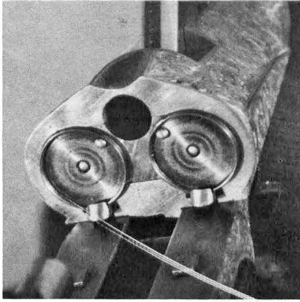 The Darne breech face, showing the obturator disks, the extractor hooks (at 6 o’clock) and the ejector pins. The large hole receives the round barrel lug, the latter secured by a vertical bolt. However, the main bolting is done by the toggle arm actuated by the operating lever, seen raised here.