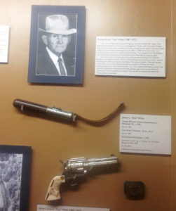 A tear gas billy club and the engraved Colt Model P revolver with personalized grips of Texas Ranger “Doc” White. 