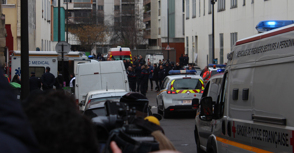Journalists, policemen, and emergency services in the street of the shooting, a few hours after the January 2015 attack. Photo by Thierry Caro