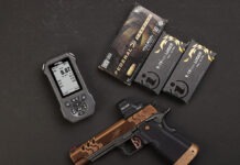 Double Alpha EDGE Shot Timer: The Timer Never Lies The Double Alpha EDGE Shot Timer sitting next to a Kimber pistol and three boxes of ammo on a black background.