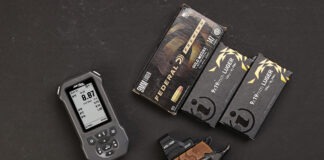 Double Alpha EDGE Shot Timer: The Timer Never Lies The Double Alpha EDGE Shot Timer sitting next to a Kimber pistol and three boxes of ammo on a black background.
