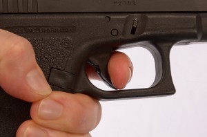 Glock’s in-trigger safety prevents the pistol from firing unless the center spar on the trigger is pressed. Thus, inadvertent contact with the side of the trigger is insufficient to discharge the pistol, but anything that presses against the center of the trigger face can make the gun fire.