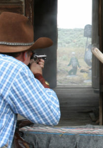 Cowboy Action competitions often demand precise shots, such as this one where a competitor attempts to hit a target through two doorways.