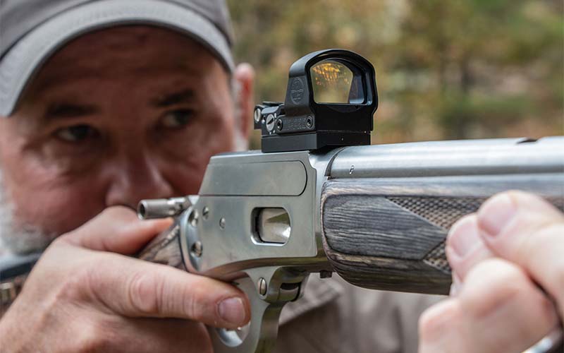 Lever-action rifle aiming red dot
