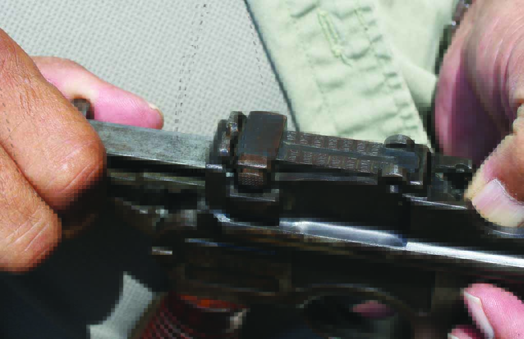 Author’s left thumb depresses a C96’s magazine follower as right hand closes the bolt on an empty chamber…an awkward procedure by today’s standards.