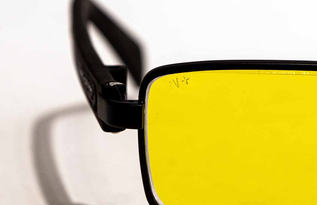 The “V” marking on the lens identifies it as photochromic, or transition, lenses. The “+” means the lenses meet ANSI safety standards.