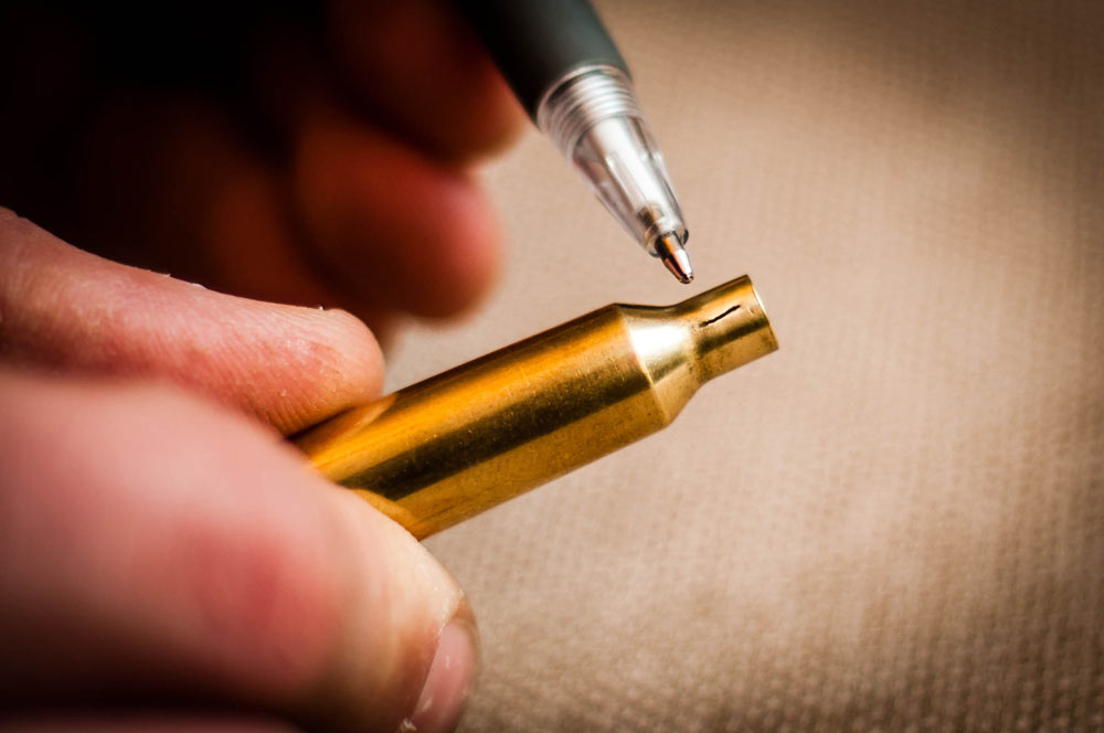 A close inspection of brass cartridges before every reloading is a must. Fine cracks such as the one above on the neck of the case render it useless.