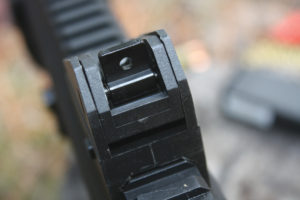 Rear sight is adjustable for windage and elevation, and features both a square notch and peep apertures. 
