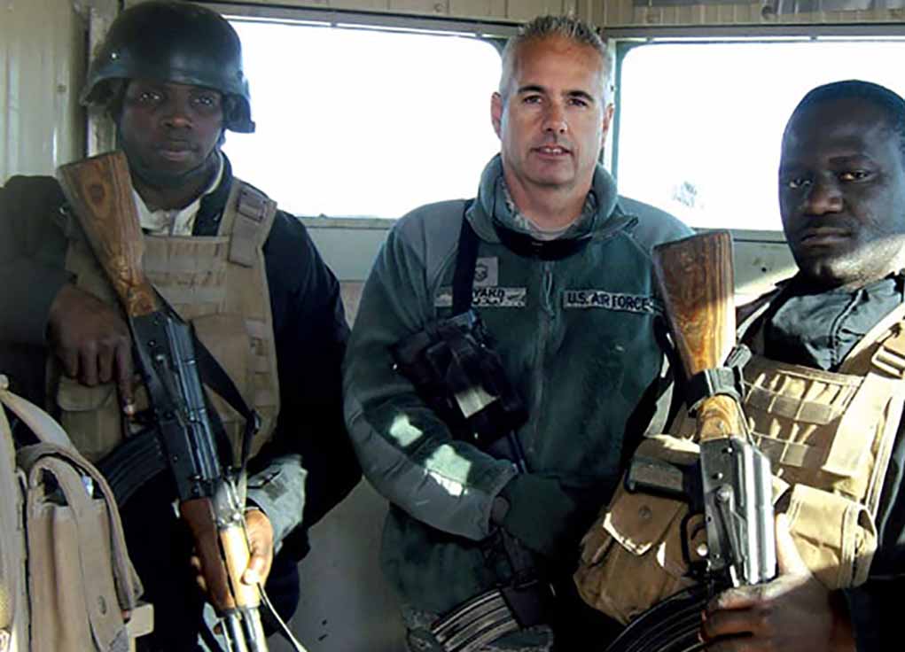 Ugandan Security Forces in Iraq holding WASR AKs, standing with US contractor