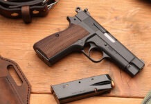 First Look: Springfield Armory SA-35 4” A Springfield SA-35 4" pistol laying on a wooden table next to a loaded magazine, a leather holster and a belt.